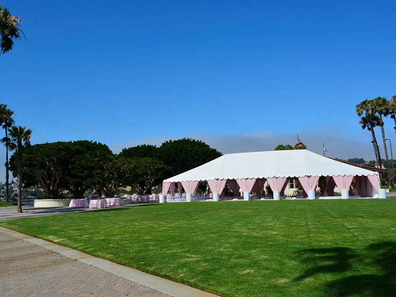 Outdoor event tent on a large lawn.