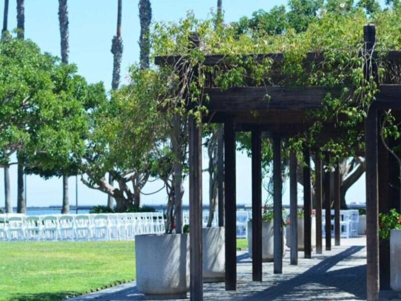Wooden arbor walkway by a lawn.